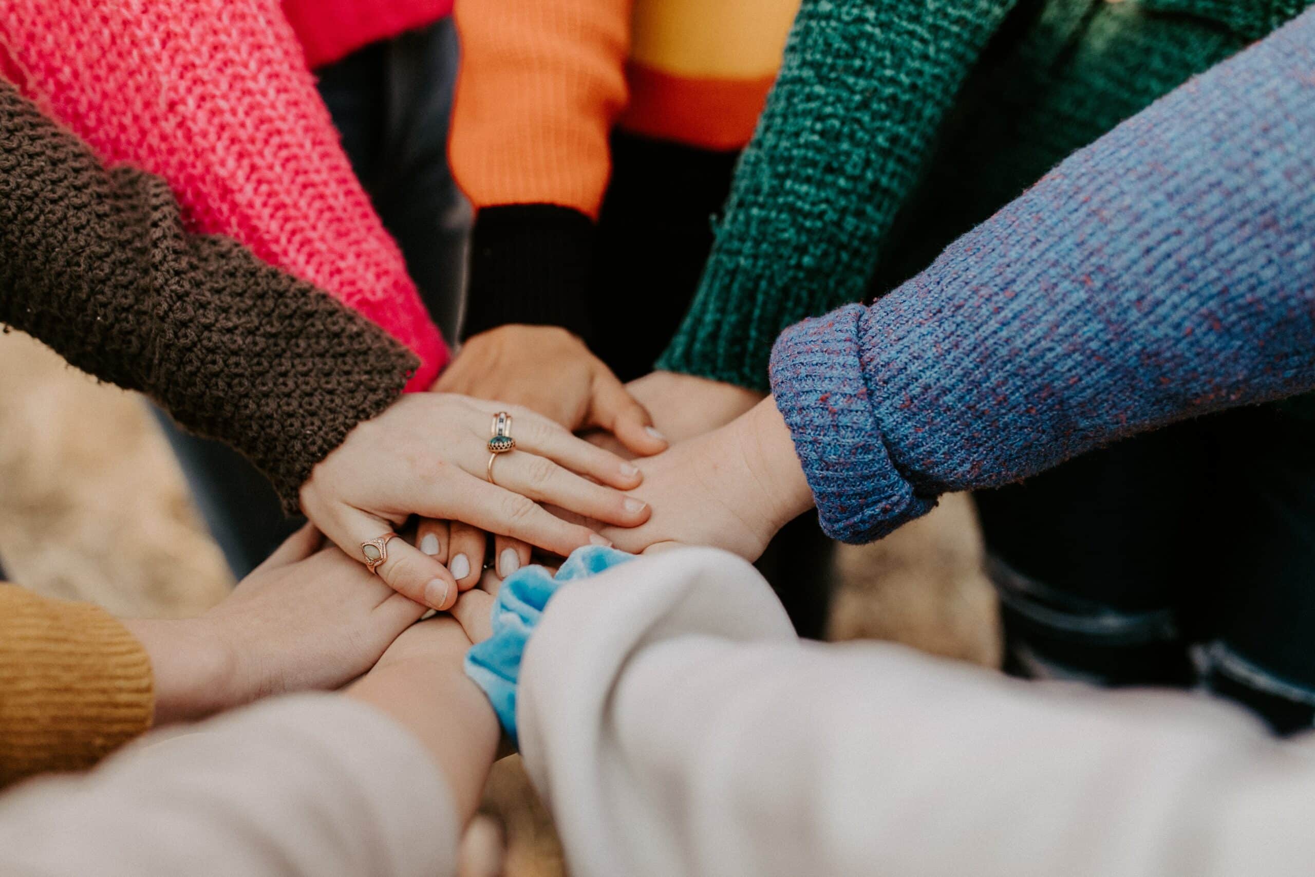 diversity of hands grouped on top of each others hands showing support Your People Partners diversity of hands grouped on top of each others hands showing support