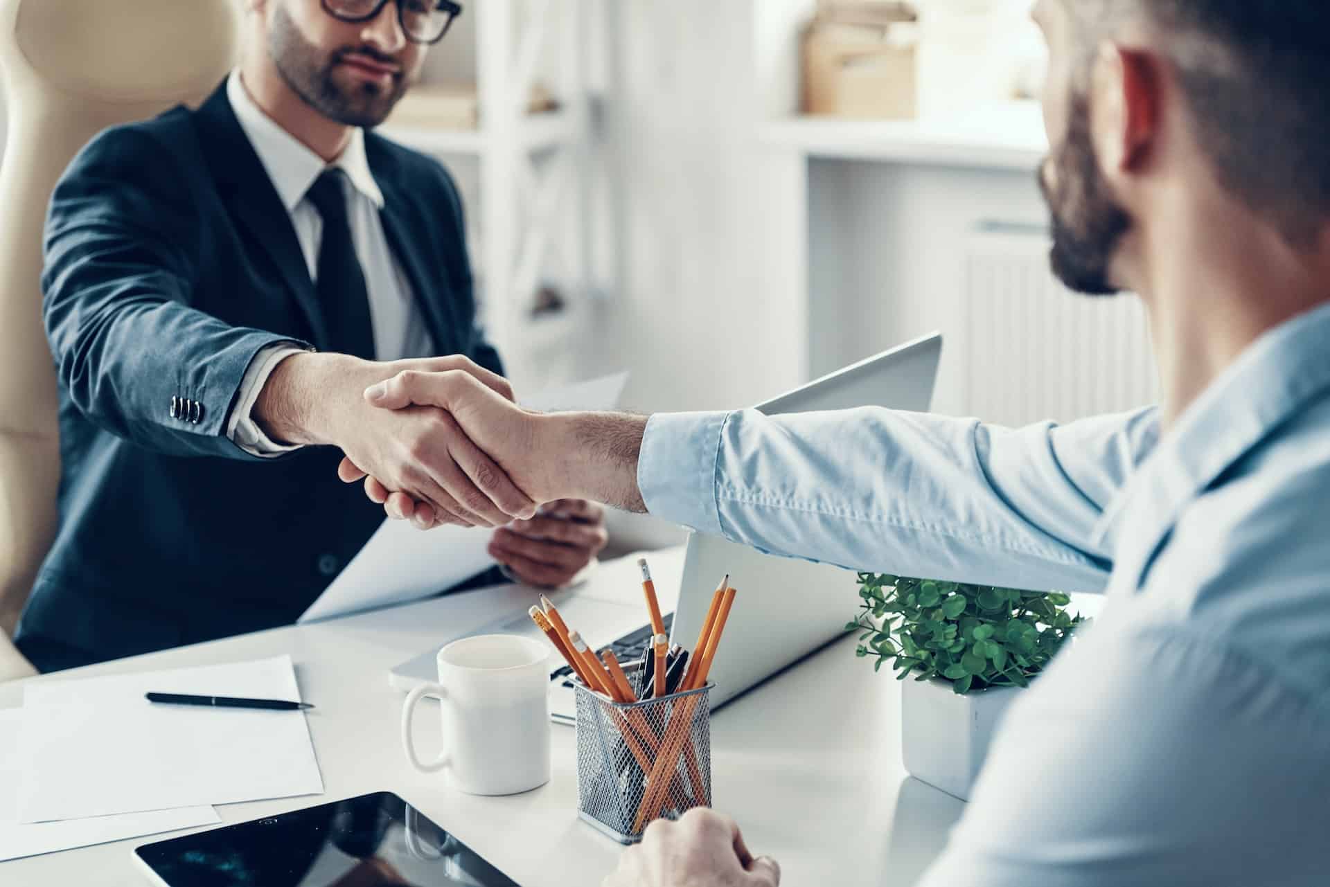A picture of people shaking hands at an interview - Your People Partners